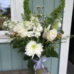 A vase filled with white flowers on top of a table.