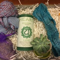 A box of items including a candle, plant and other accessories.