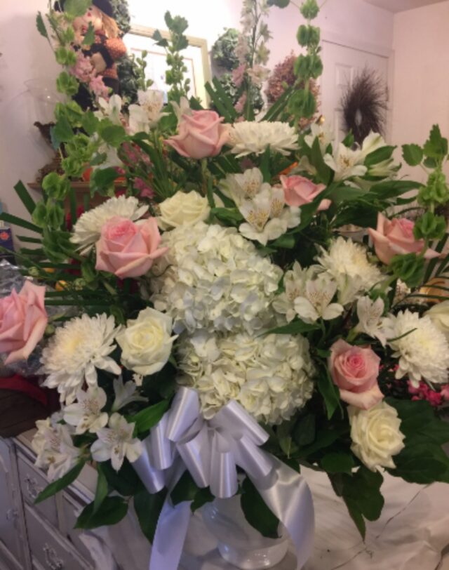 A bouquet of flowers with pink roses and white hydrangeas.