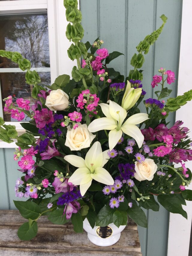 A bouquet of flowers sitting in front of a blue door.