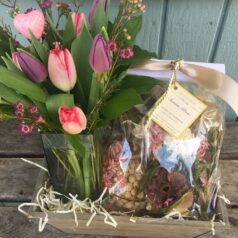 A wooden crate with flowers and nuts in it.