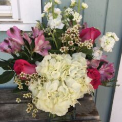 A bouquet of flowers sitting on top of a wooden table.