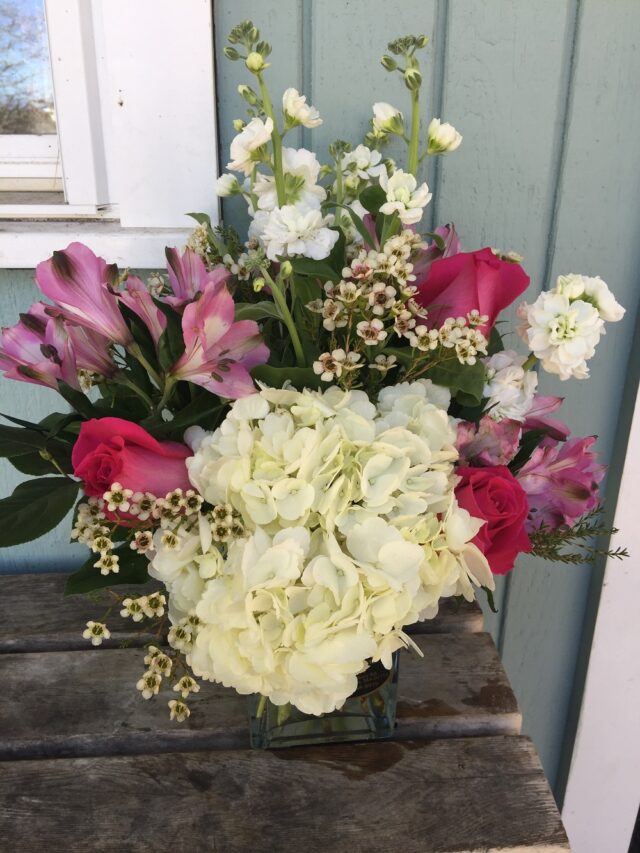 A bouquet of flowers sitting on top of a wooden table.