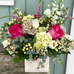 A bouquet of flowers in a vase on the porch.