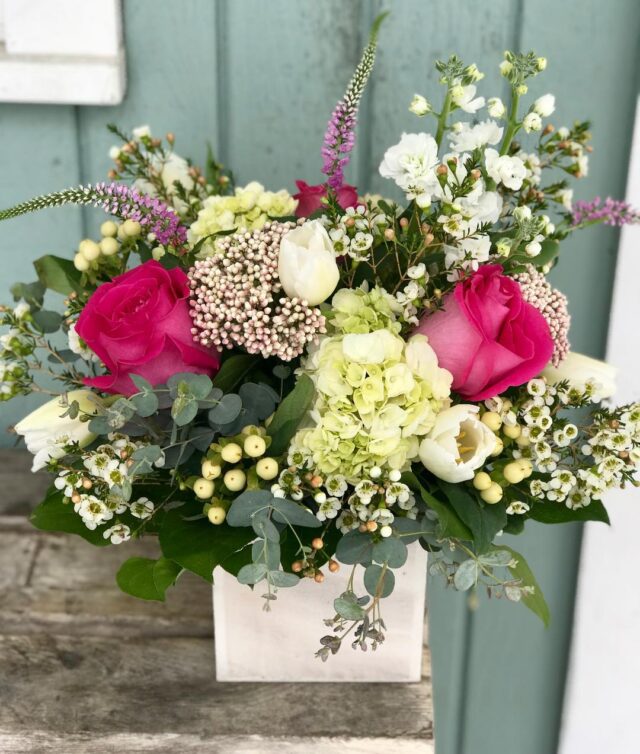 A bouquet of flowers in a vase on the porch.