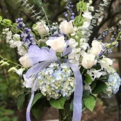 A bouquet of flowers with blue ribbon in front.