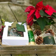 A wooden box with some flowers and a bottle of wine