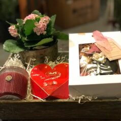 A box of chocolates and candles on top of a table.