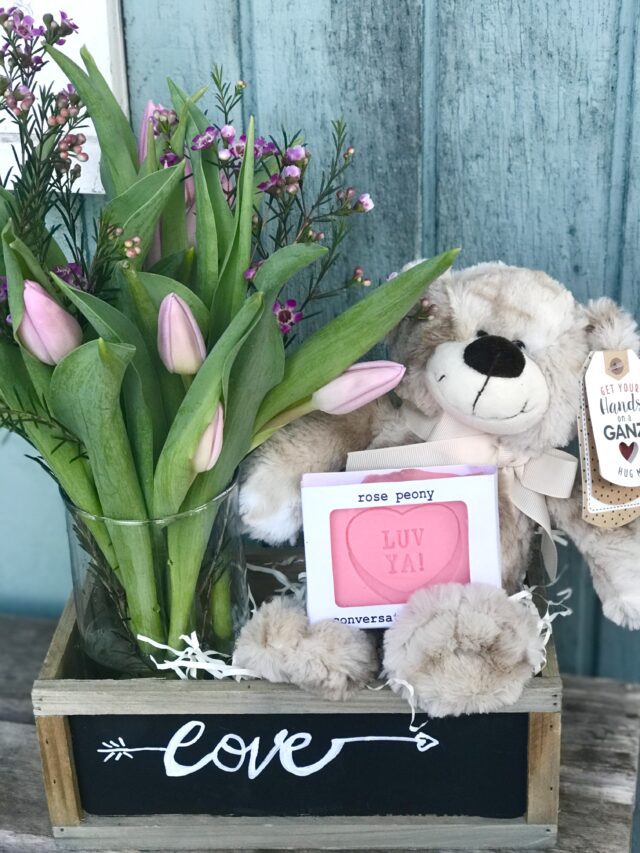 A Teddy bear With a Vase of Pink Tulips