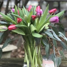 A vase filled with pink flowers on top of a table.