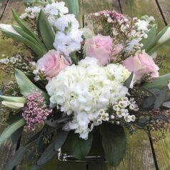 A bouquet of flowers sitting on top of a wooden table.