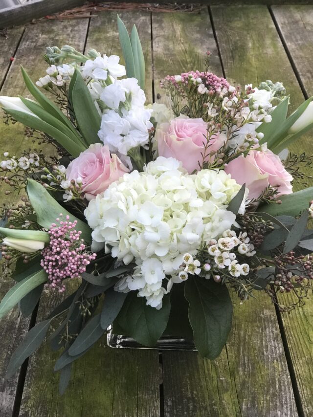 A bouquet of flowers sitting on top of a wooden table.