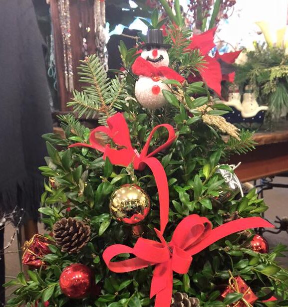 A christmas tree with red ribbon and ornaments.