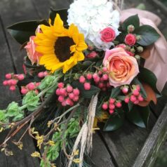 A bouquet of flowers on top of a wooden table.