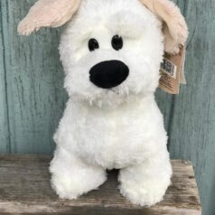 A white stuffed dog with a brown ear tag.