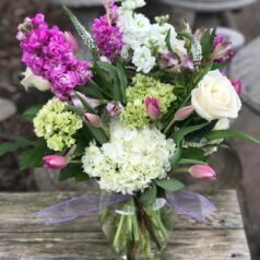 A vase filled with flowers on top of a wooden table.