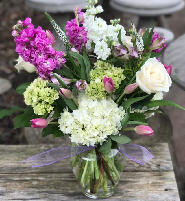 A vase filled with flowers on top of a wooden table.