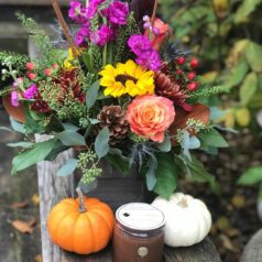 Autumn floral arrangement with candle and pumpkins.