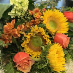 Sunflowers and roses in a vibrant bouquet.