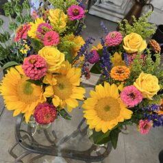 Colorful floral arrangement with sunflowers and roses.